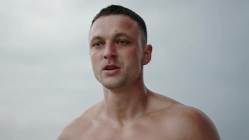 Shirtless Man Runs Towards Camera in Urban Setting