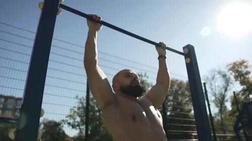 Sportif faisant des tractions sur le terrain de sport au Ralenti