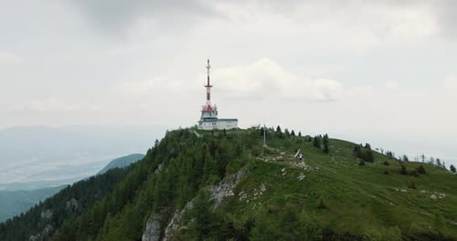 Vue panoramique prise par un drone du sommet de la montagne Uršlja Gora avec une tour radio, couverte d'ombres provenant de nuages