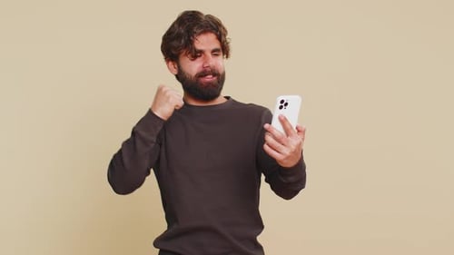 Excited Man Celebrating Good News on Smartphone