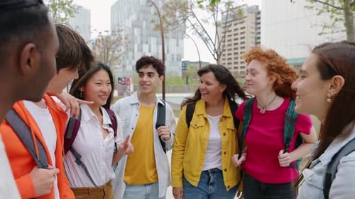 Grupo de jovens amigos felizes conversando fora do campus universitário