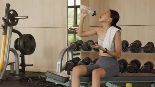 Athletic Woman on Phone Taking a Water Break