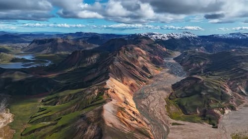 Aerial view of Landmannalaugar’s colorful rhyolite peaks and winding glacial rivers under bright