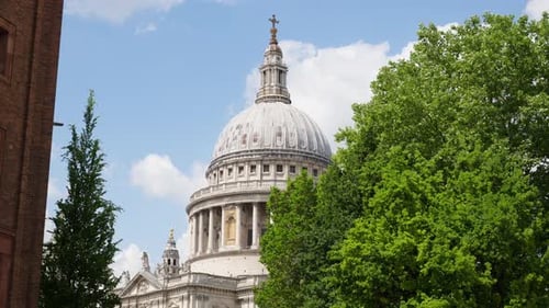 The Dome of St. Paul's Cathedral rising above the trees with a clear blue sky in the background in L
