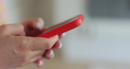 Young Adult Typing on Mobile Phone Indoors