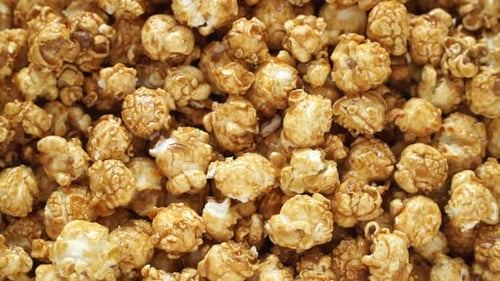 Top View of Fresh Sweet Caramel Popcorn Rotates on Board