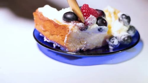 Spoon Scoops Creamy Cake with Berries Close Up