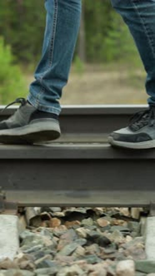 Person Walking on Railroad Track in Rural Setting