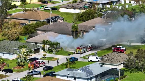 Vista aérea de una casa en llamas y los bomberos apagando las llamas después de que un cortocircuito provocara una chispa