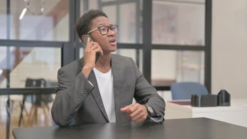 Man in Office Talks on Cellphone
