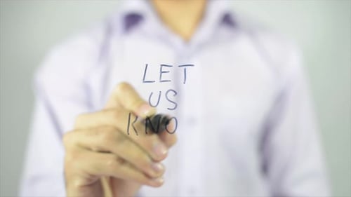 Man Writes 'Let Us Know' on Clear Surface