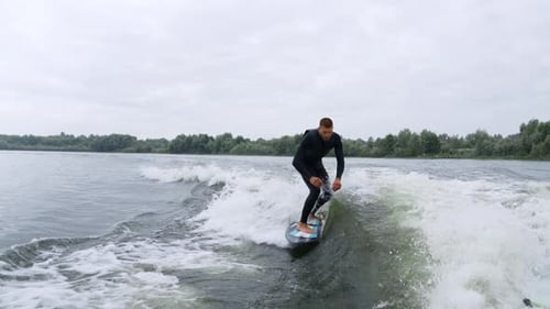 Man Wake Surfing on Lake Behind Boat