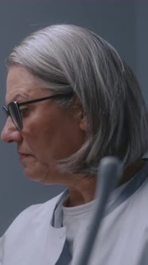 Mature Female Doctor Looks at Monitor of Ultrasound Machine