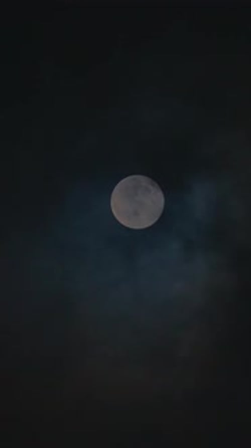 Vertikaler Mond, der sich zwischen Wolken bewegt