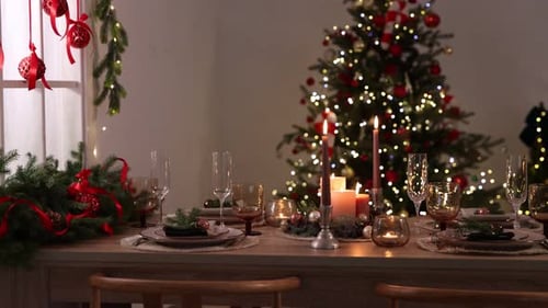 Beautiful Christmas Dinner Table with Lit Candles and Tree