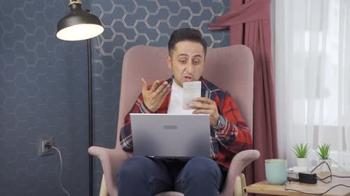 Surprised Man Works on Laptop at Home