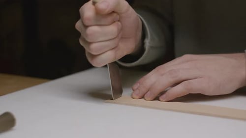 Hands Cut Leather With Sharp Blade in Workshop