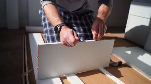 Caucasian Man Assembles Furniture Fit Table or Mount Wardrobe