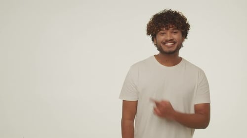 Excited Man Gesturing to Side in Studio