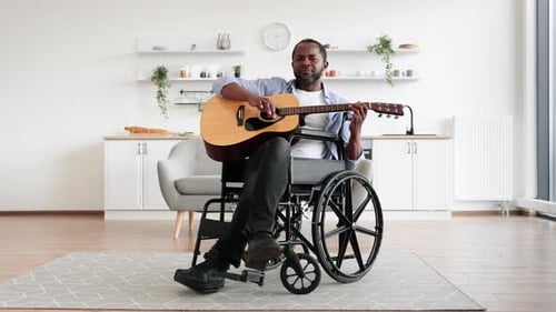 Man in Wheelchair Playing Guitar and Singing
