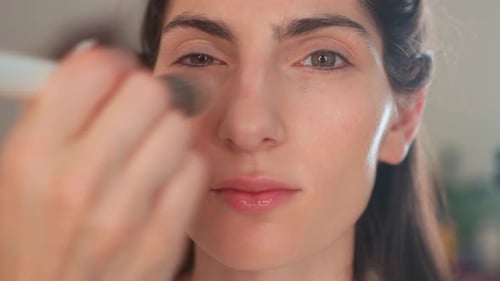 Makeup Artist Applying Highlighter to Woman Face in Studio