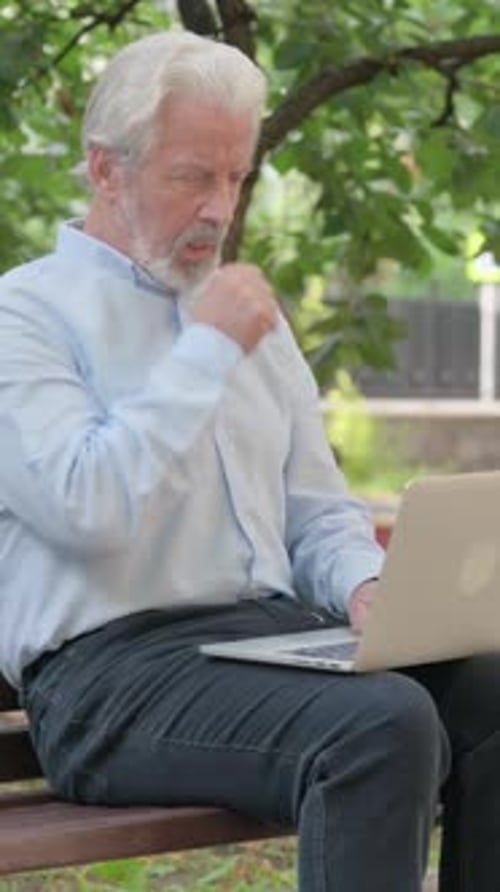 Senior Man Using Laptop Sitting on Park Bench