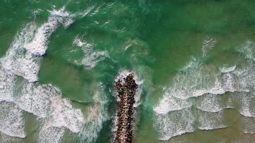 Calm Waves hitting a Wave breaker, Top down aerial footage.