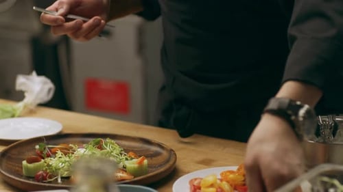 Chef plating a gourmet salad in restaurant kitchen