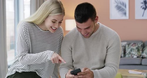 Happy Couple Laughing Looking at Phone Together
