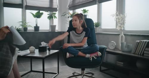 Kinderpsychologin zeigt einem Mädchen Illustrationen, das einen psychologischen Test durchführt