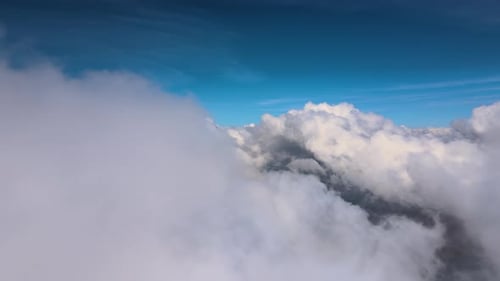 Aerial View From Airplane Window at High Altitude of Earth Covered with White Puffy Cumulus Clouds
