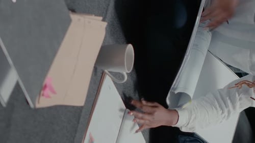 Adult Reviews Paperwork at Desk in Office