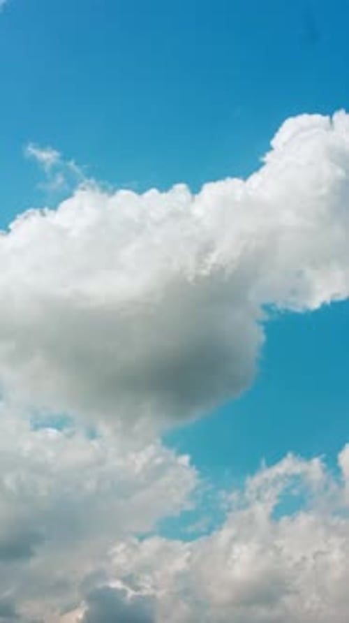 Fluffy White Clouds Drifting Across a Blue Sky