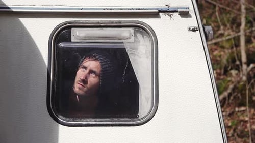 Young Adult Looking Out Camper Window