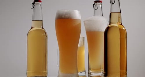 Bottles and Glasses of Golden Refreshing Beer
