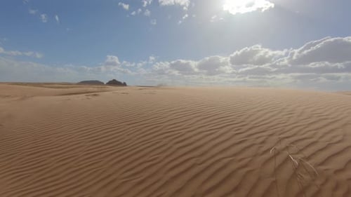 Sonnige, windgepeitschte Sanddünen.