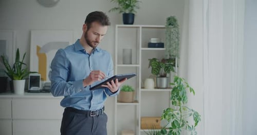 Man Using Stylus and Tablet Indoors