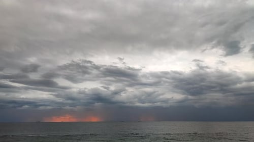 Movement Large Gray Rain Clouds Falling Rain Yelloworange Spot of Rising Sun