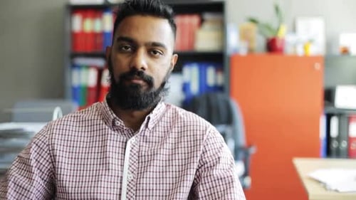 Man Smiling at Camera in Office Setting