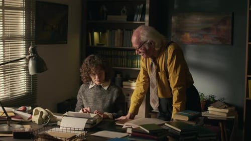 Escritora sénior dictando un libro a una mecanógrafa en estudio