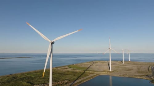 Panoramic view a source of clean energy, four wind turbines in a row and rotating blades on a summer