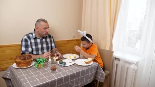 1. Vater und Sohn feiern Ostern. Sie bereiten einen Korb vor, malen Eier und haben Spaß.