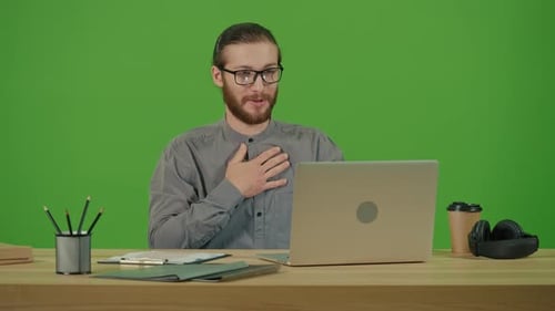 Man Communicates During Virtual Meeting on Laptop