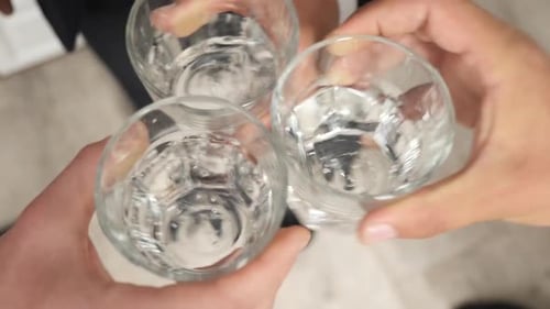 134s. Homens brindam tocando três copos de álcool. Comemorando em uma festa
.