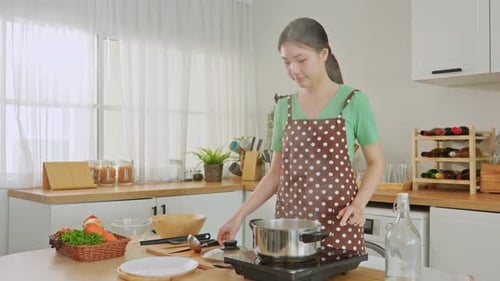 Asian young woman cooking healthy foods in kitchen in morning at home.
