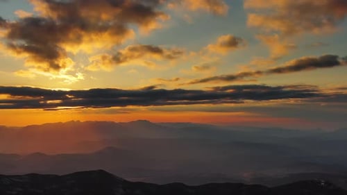 Orange Sunset Over Mountain with Dramatic Clouds