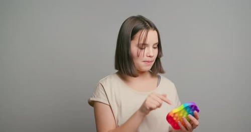 Teen Girl Smiles with Rainbow Pop-it Fidget Toy