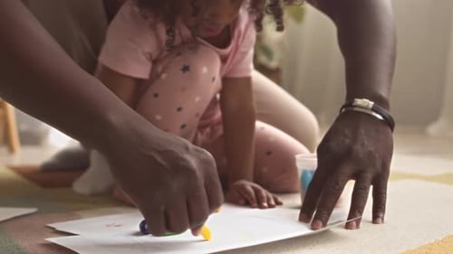 Child and Adult Drawing Together with Crayons