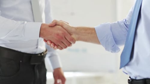 Businessmen shake hands in agreement after a successful meeting at the office