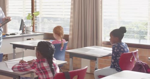 Teaching in classroom, female teacher engaging with students in school setting